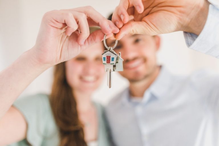 A couple holding house keys.